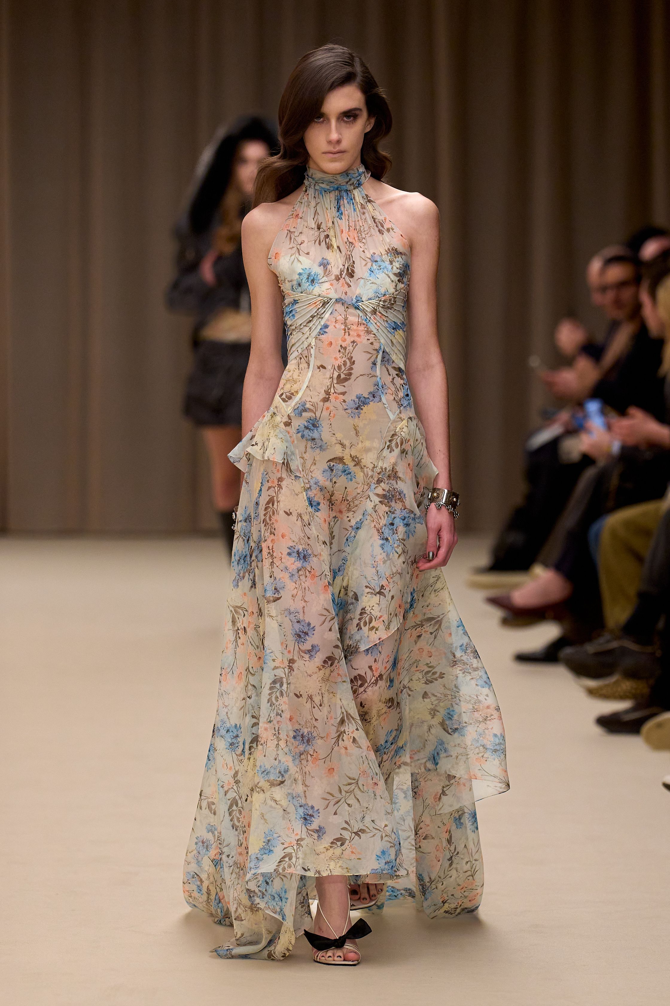 McQueen 本季延续品牌标志性的暗黑浪漫：收腰短裙套装、雕塑感肩线、精致刺绣礼服与戏剧化斗篷让整场秀充满哥特式戏剧张力。细腻蕾丝、金属光泽和建筑般轮廓塑造出强烈女性力量，同时保留麦昆一贯的浪漫与神秘-顽石频道趋势研究